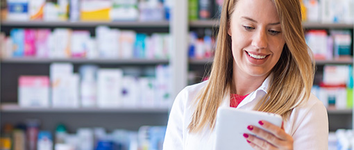 ELGA Anschluss für Apotheken mit Magenta Business Apothekerin prüft Daten auf Tablet, digitale Unterstützung in der modernen Medikamentenberatung
