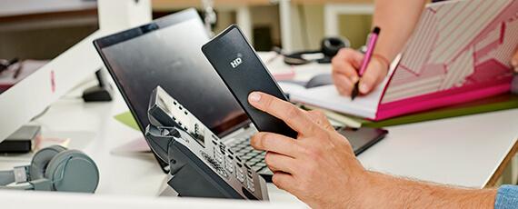 Büro-Schreibtisch mit IP-Telefon und Laptop für moderne Kommunikation