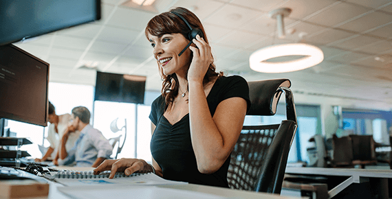 eine Frau telefoniert mit einem Headset in einem Büro