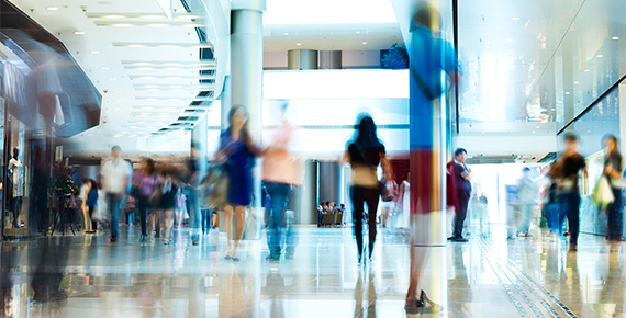 Menschen bewegen sich durch moderne Ladenpassage, Besucherfrequenz im Einzelhandel