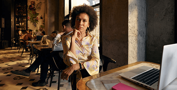 Eine Frau sitzt entspannt in einem Cafe.