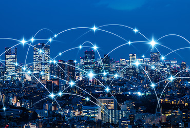 Vernetzte Stadt bei Nacht Leuchtende Netzwerkverbindungen über einer nächtlichen Großstadtskyline