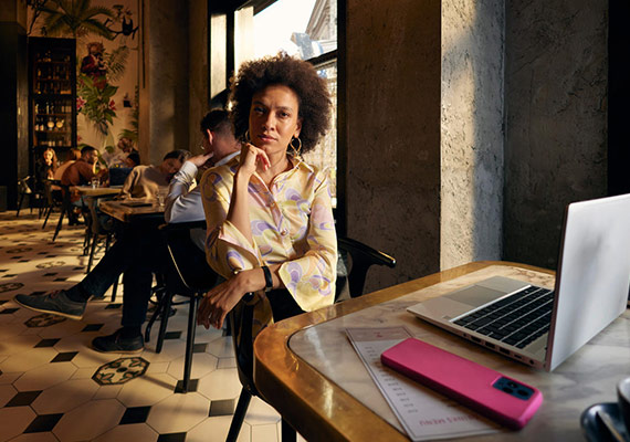 Mobile Working Eine Frau am Tisch, die konzentriert auf ihren Laptop schaut.