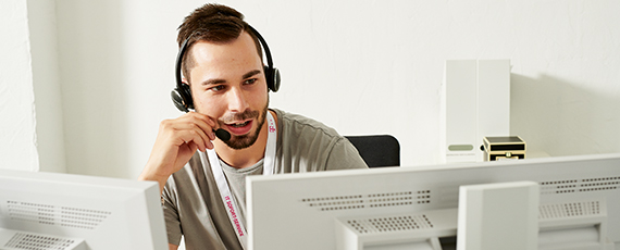 Professioneller Kundenservice per Headset Mitarbeiterin mit Headset bei digitaler Kommunikation im modernen Büro