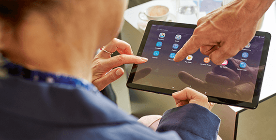 Eine Frau hält ein Tablet Eine Frau hält ein Tablet-Computer in der Hand und schaut darauf.