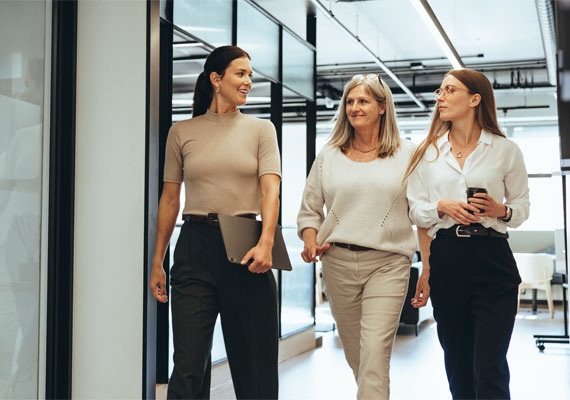 Drei lächelnde Business Frauen unterwegs im Office