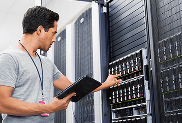 Ein Mann mit einem Tablet in der Hand in einem Server Raum