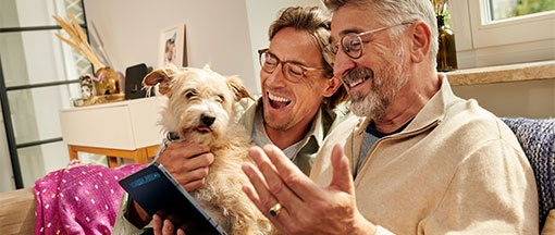 Zwei Männer und ein Hund mit Tablet