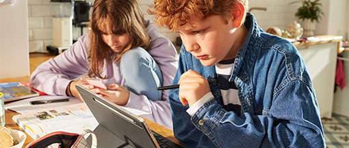 2 Kinder mit Tablet und Mobiltelefon