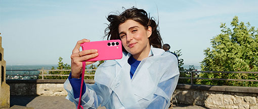Eine junge Frau im Freien macht ein Selfie.