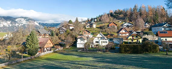 Aigen im Ennstal Panoramablick auf Aigen im Ennstal mit Einfamilienhäusern am Hang, umgeben von Wäldern und Bergen mit leichtem Schneebelag.