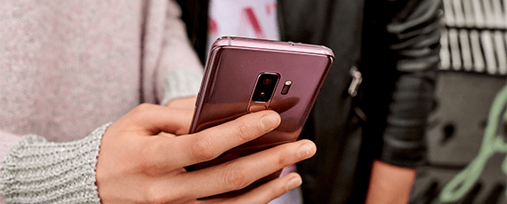 Magenta Business Blog Großaufnahme eines Smartphones in der Hand einer Frau