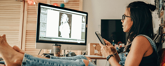 Internet zuhause Frau arbeitet kreativ am PC und Smartphone im Homeoffice – zuverlässiges Internet für digitale Bildbearbeitung und Kommunikation.