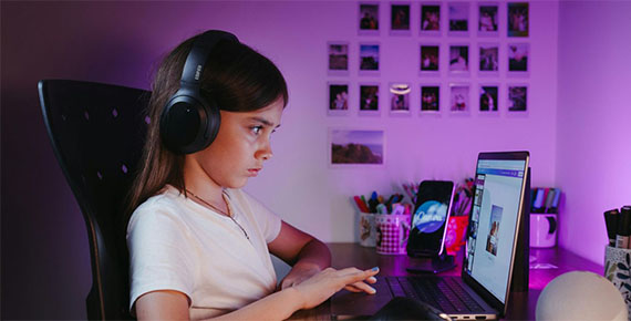 Mädchen sitzt vor dem Laptop